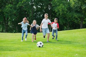 Cute,happy,multiethnic,kids,playing,soccer,with,ball,in,park
