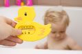 Father`s,holding,a,bath,thermometer.,little,child,taking,a,bath