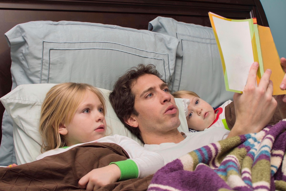 Father,reading,daughter,and,son,a,bedtime,story,in,bed