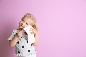 Cute,little,girl,holding,toilet,paper,roll,on,color,background.