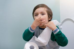 Toddler,boy,sitting,in,the,toilet,and,covers,his,nose