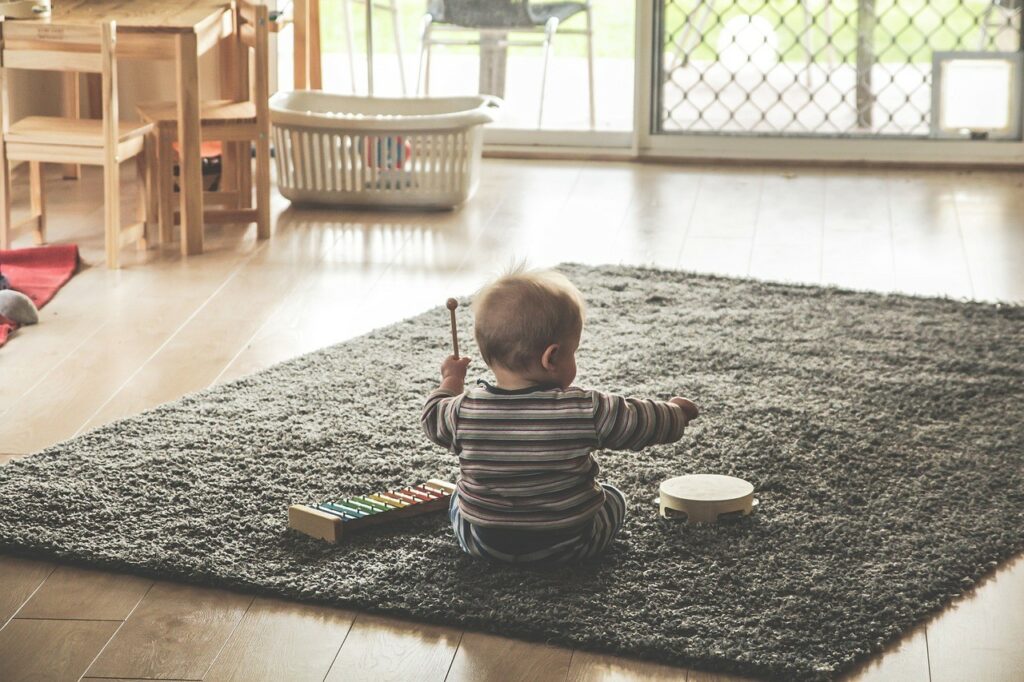 Бебе играе върху килимче в хол