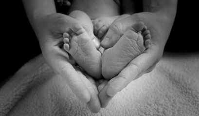 бебешки крачета в ръце на родител