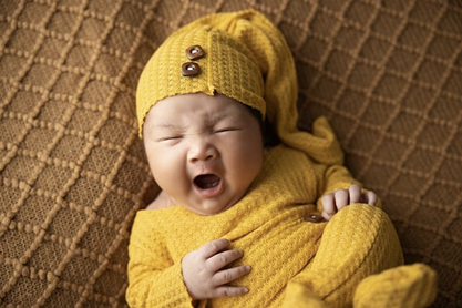 Плачещо бебе в пуловер и шапка